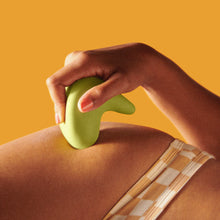 Load image into Gallery viewer, Woman holding the Kiwi vibrator by thee Pelvic people against her skin